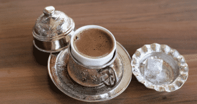 A traditional turkish coffee cup with metal details filled with turkish coffee