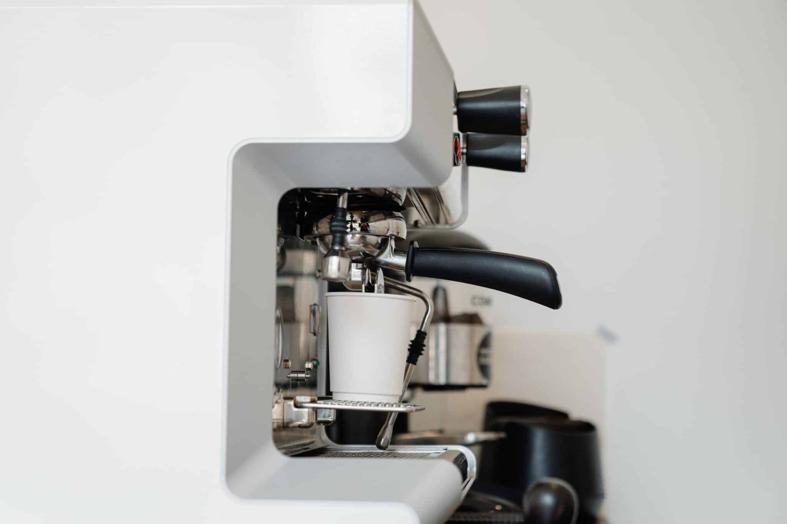 A white commercial coffee maker brewing coffee