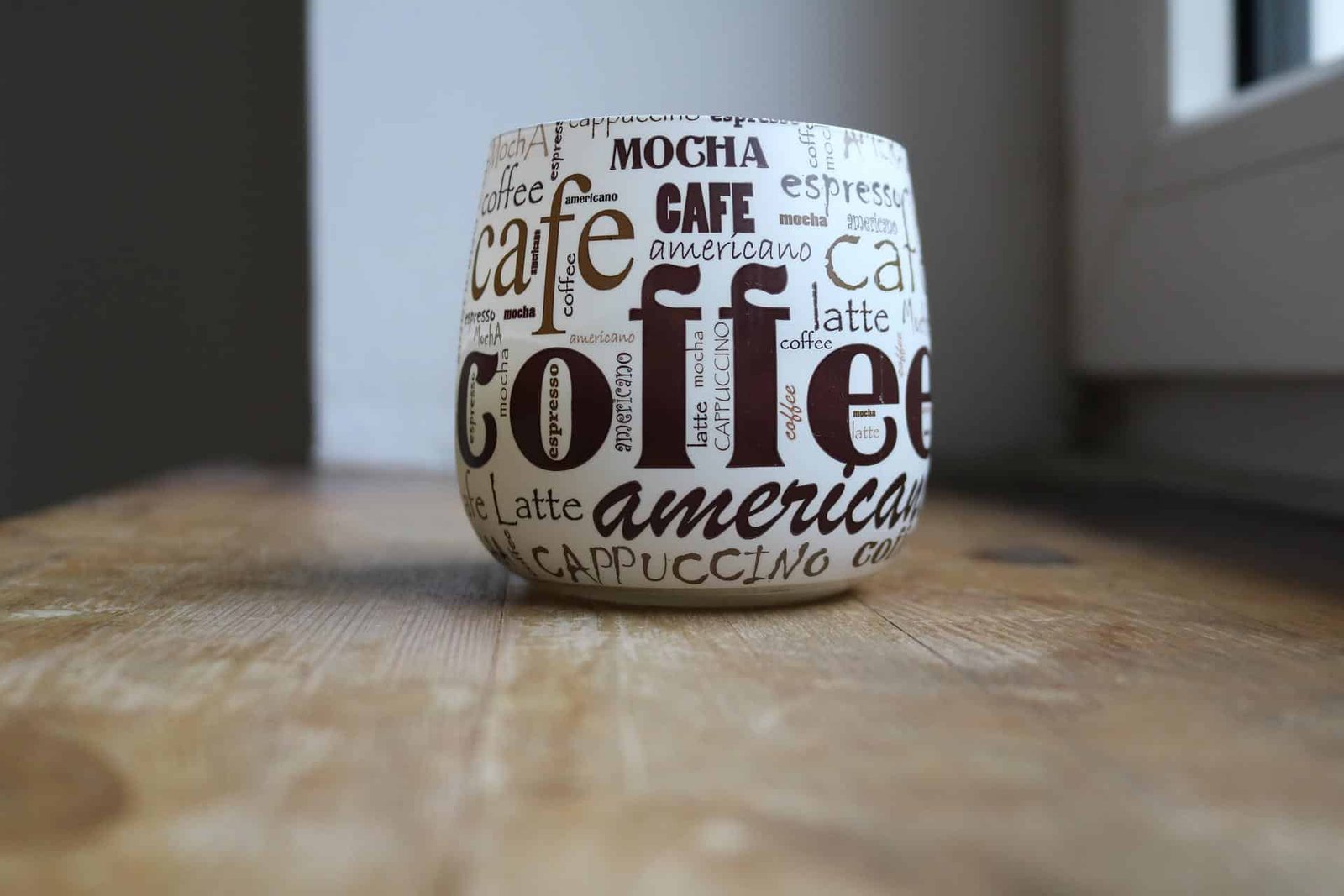 A cup with different types of coffee names written on it. Different types of coffee have different caffeine levels